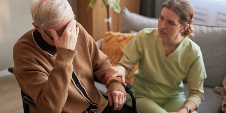 Nursing Staff Comforting Grieving Resident at Assisted Living Facility